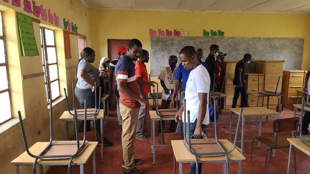 Volunteers arranging desks inside the new classroom block