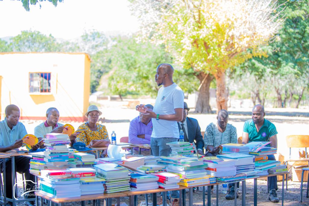 Community meeting with books and elders at Tsenga