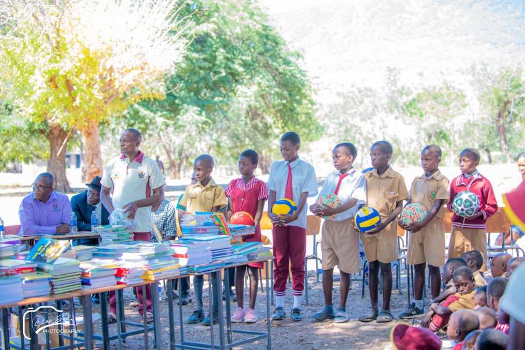 Students receiving soccer balls and sports kits